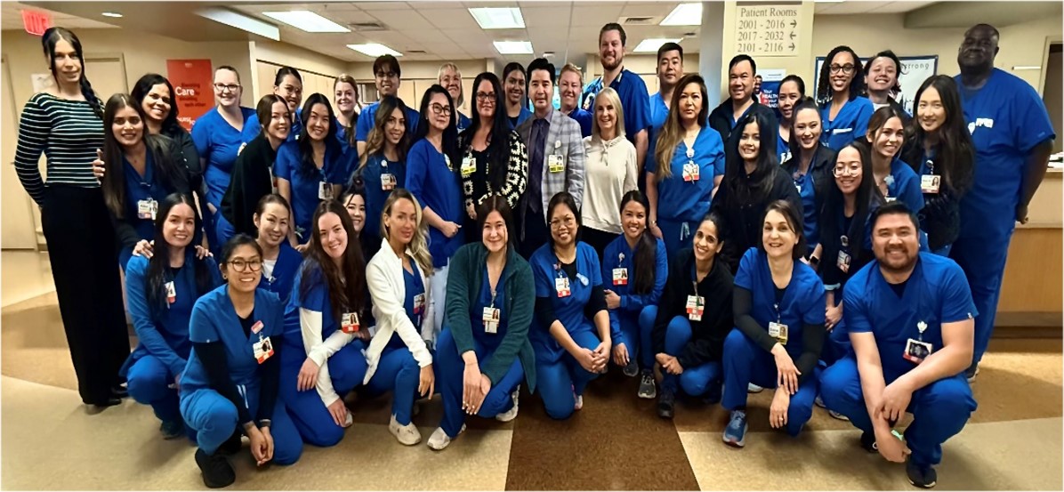 Clinical nurses in blue scrubs pose in the unit.