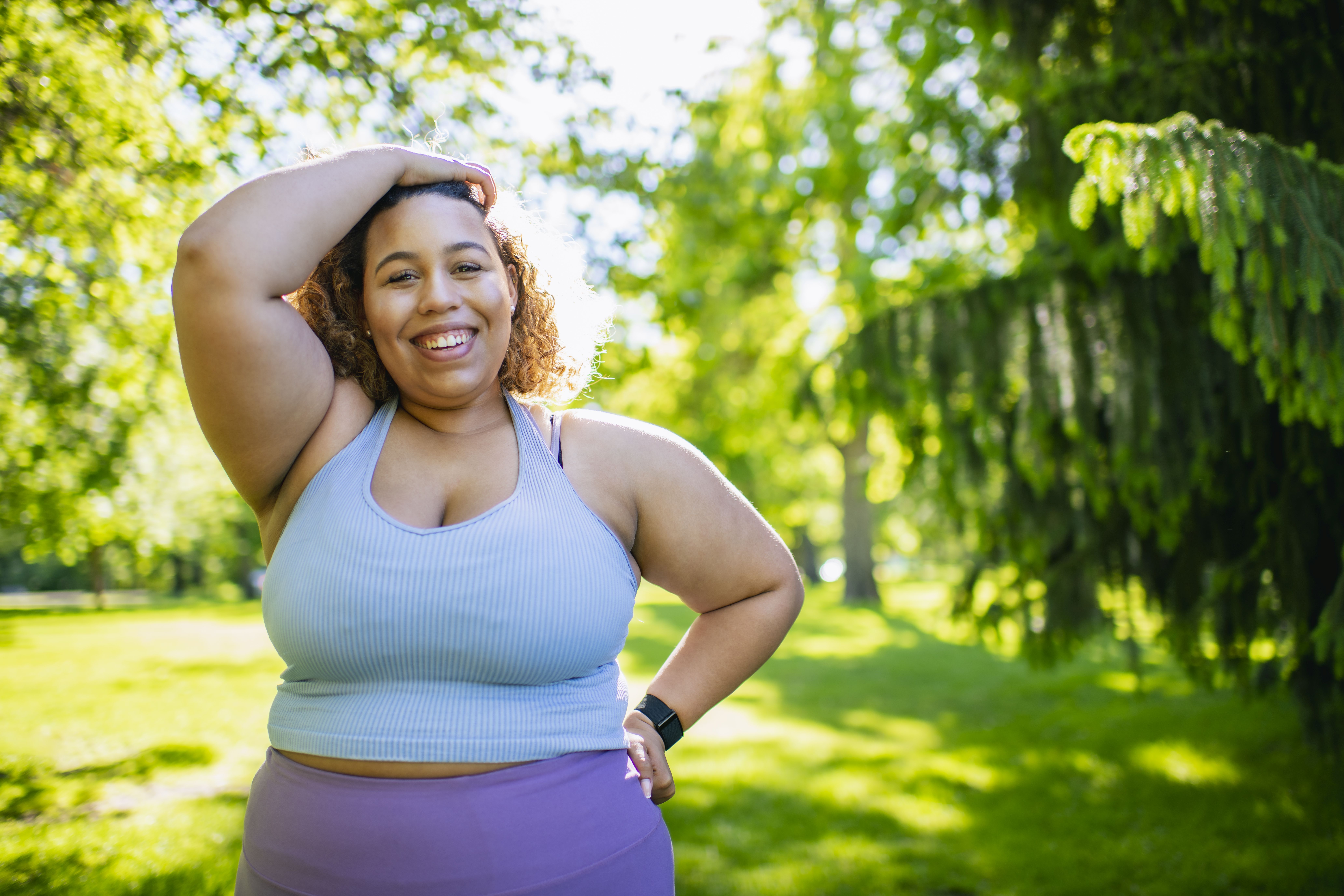 A woman dressed in athletic gear smiling outdoors