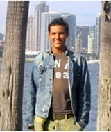 David Dow, stroke survivor, smiles outside by the bay.