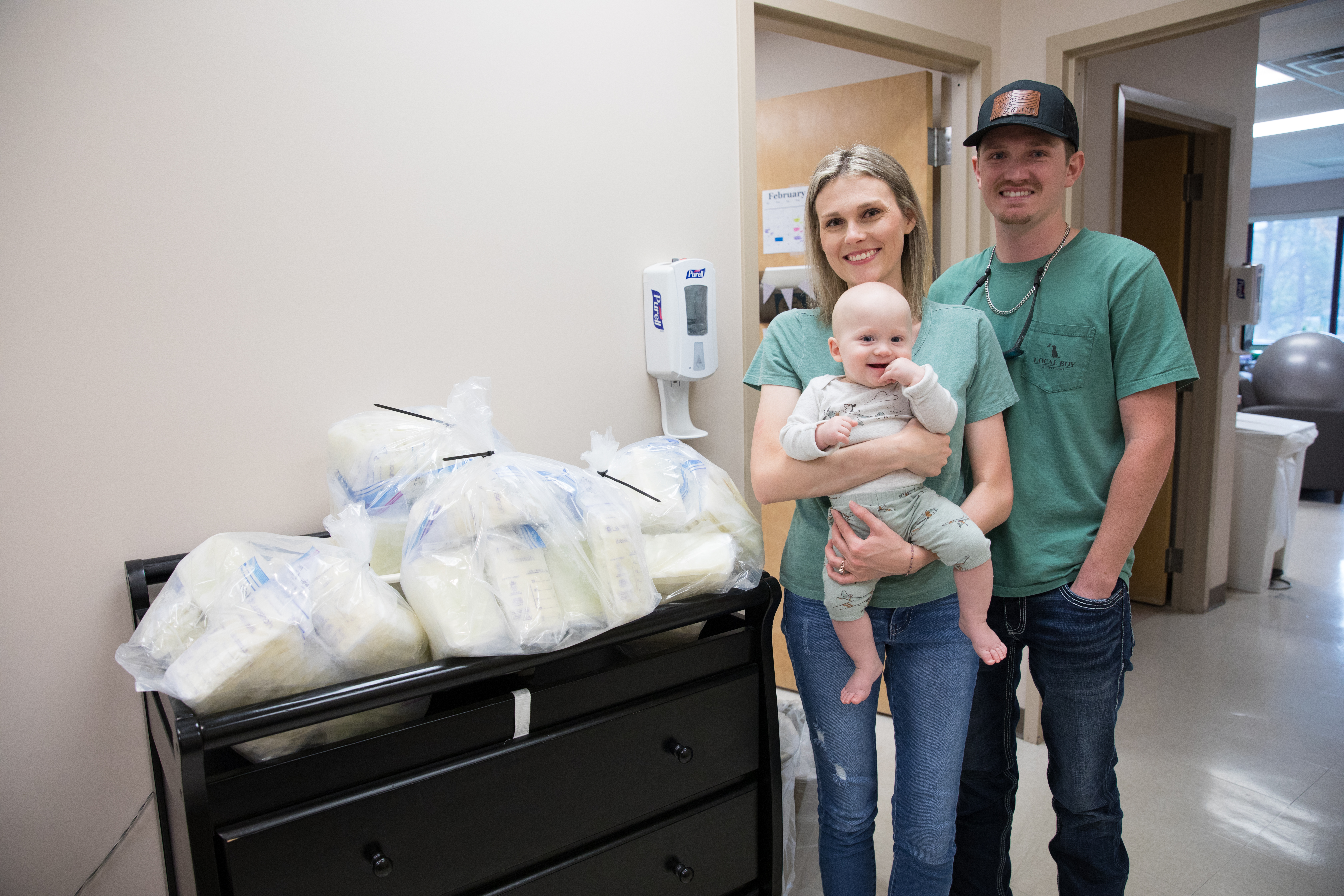 Grace Kennedy, her fiancé Jeremy and son Bentley next to breast milk donation bucket