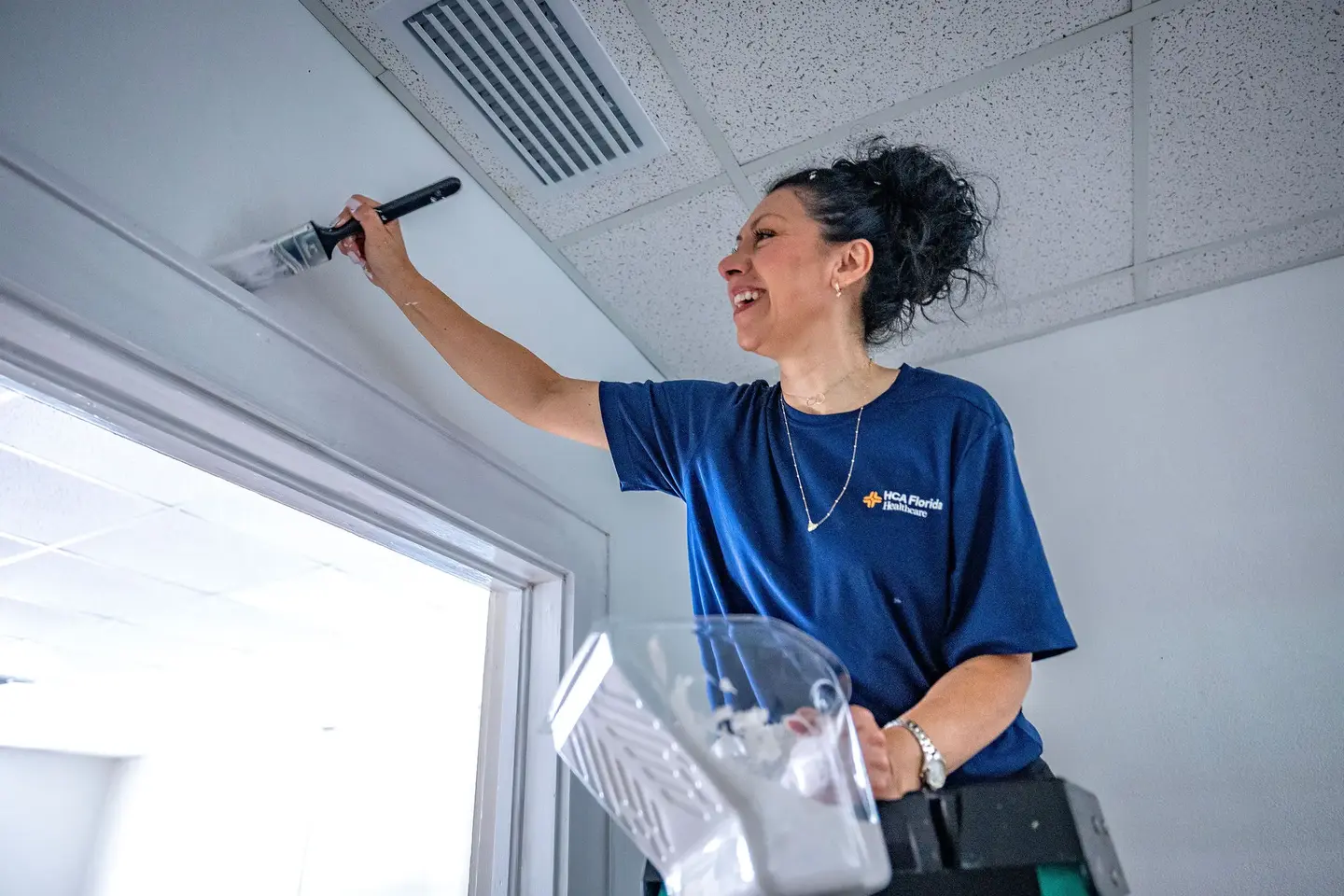 HCA Volunteer on a ladder.