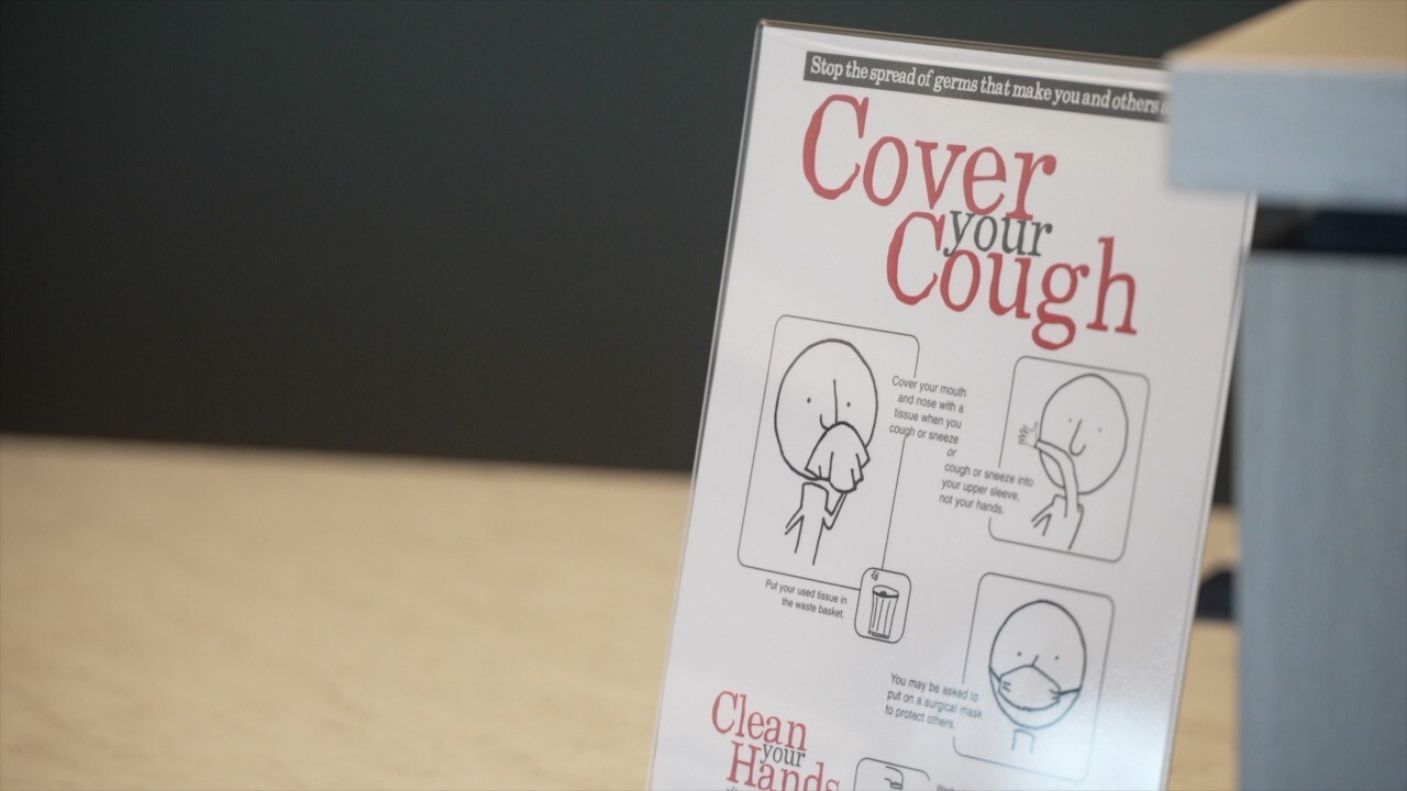 photo of a poster that says "cover your cough" with diagrams