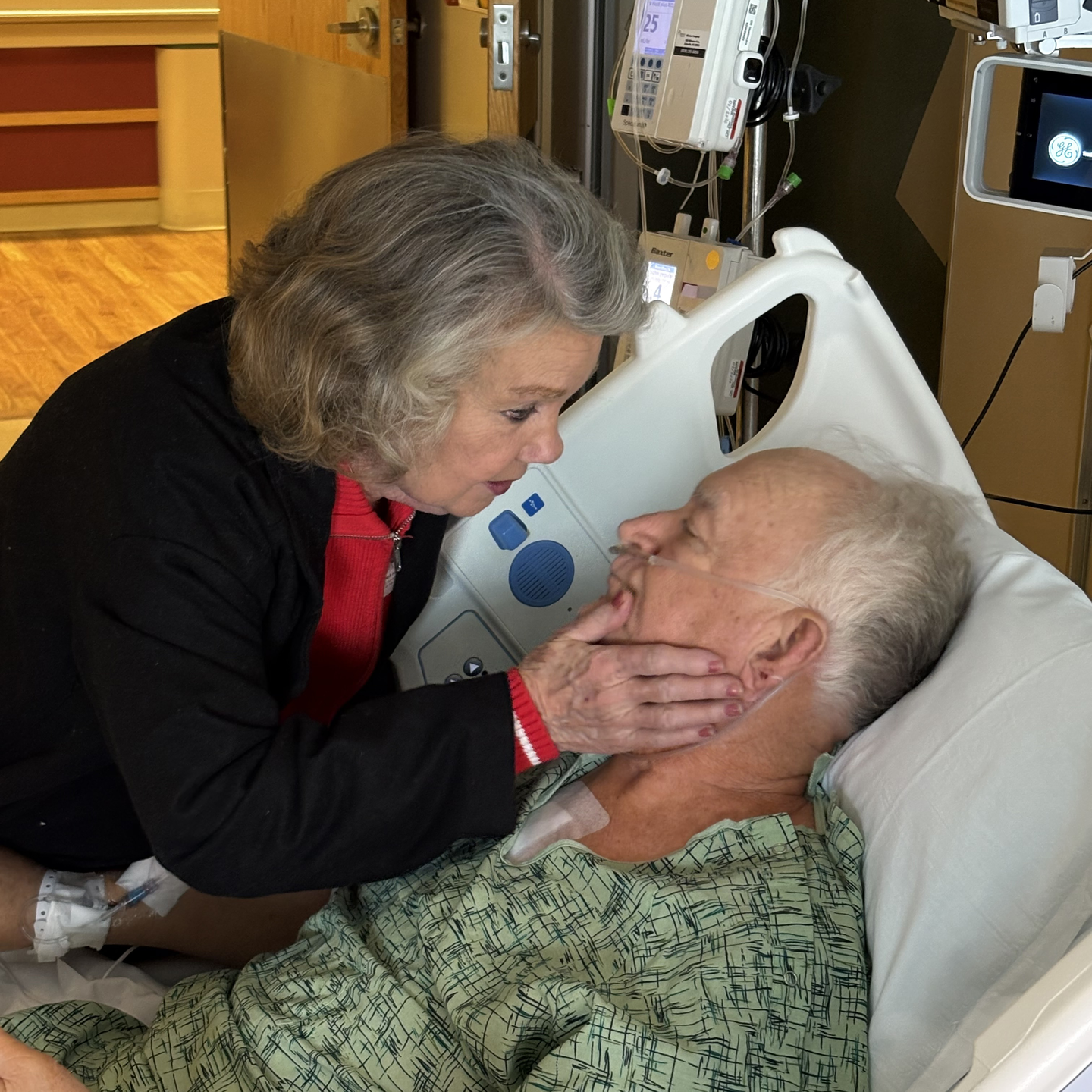 Fred Hampton in hospital bed getting face touched by wife