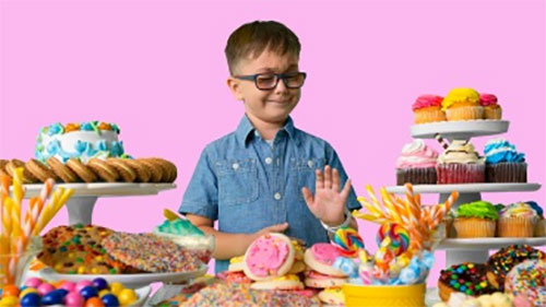 A male child front of large display of candy