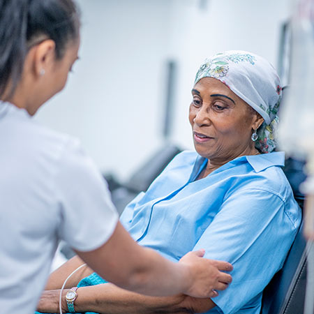 a woman in a headwrap being treated by a nurse.