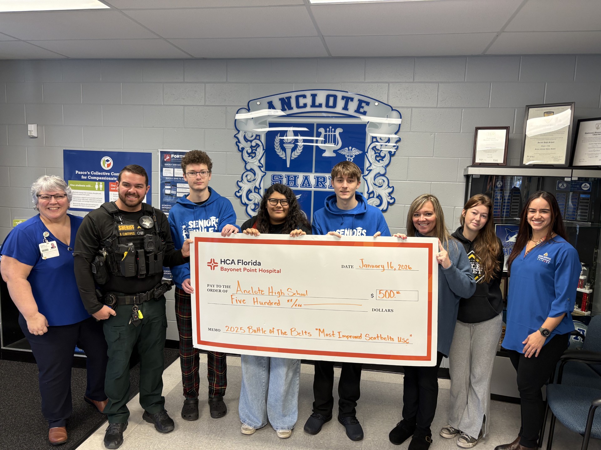 Students celebrate the donation, holding a check in a group photo.
