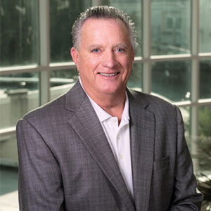 Bill Wade smiling and wearing a grey suit.