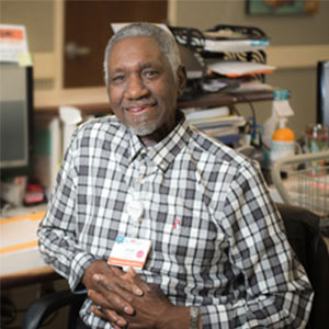 Hamiel Powell sitting at a desk with his hands clasped.
