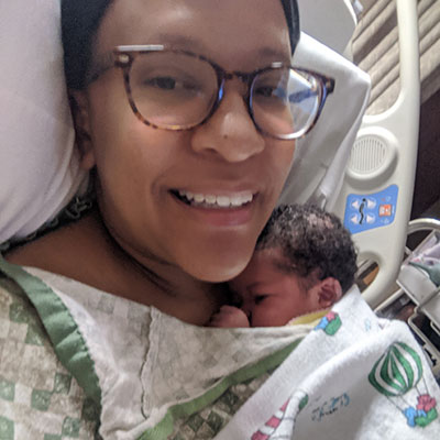 Ashley smiles as she holds her newborn baby girl, Olivia.