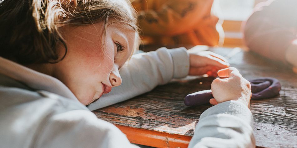 Young girl resting head on table
