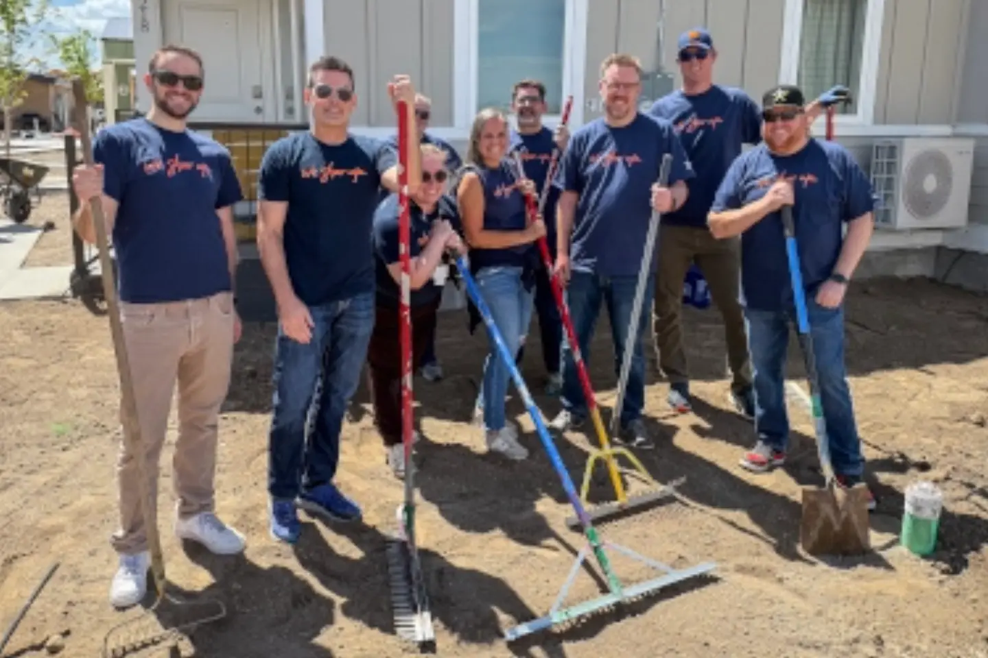 West Valley Medical Center employees smile while standing together after helping to landscape a new construction house.