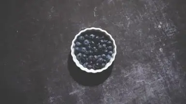 A bowl of blueberries on a table.
