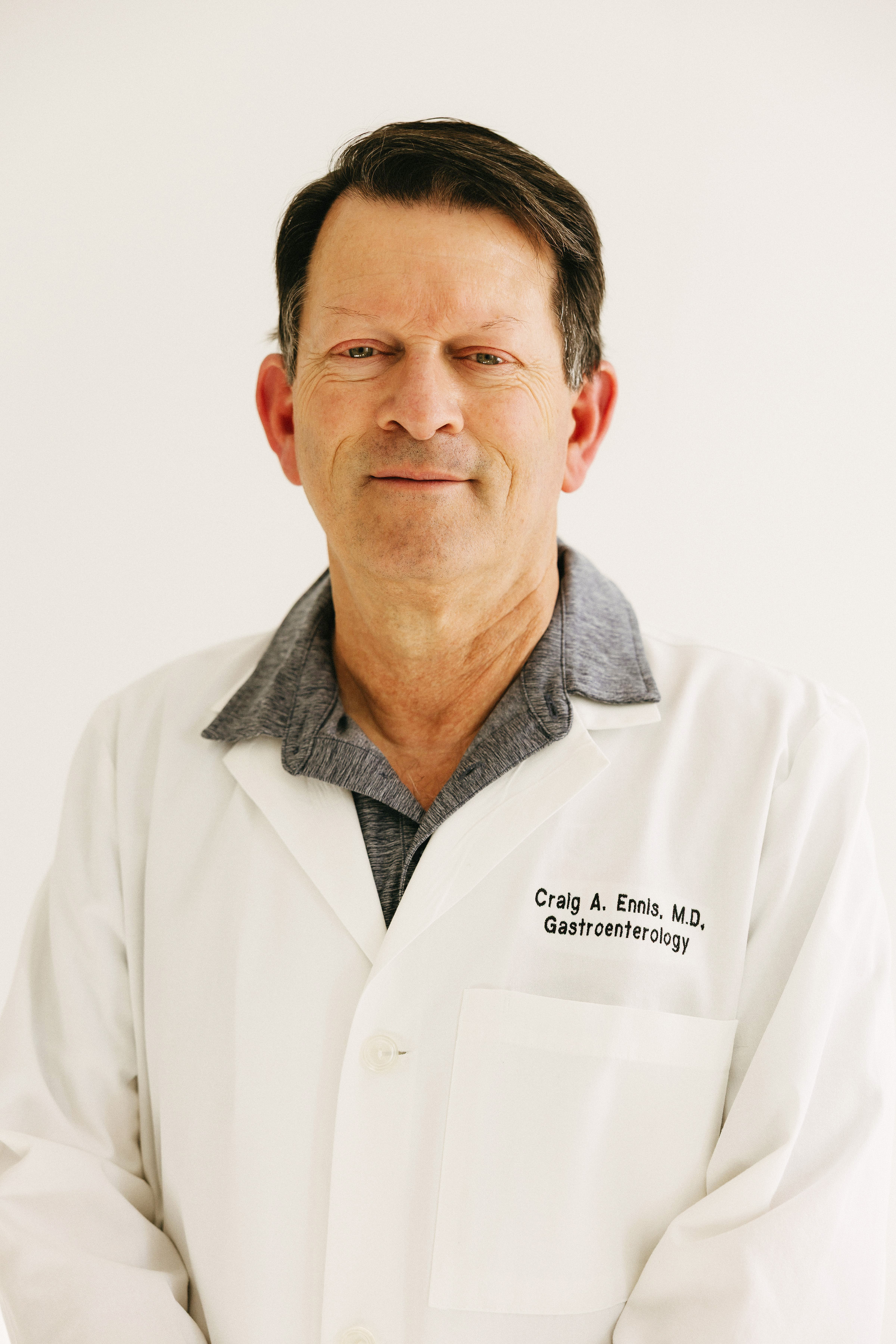 Person in a white lab coat posing against a light background.