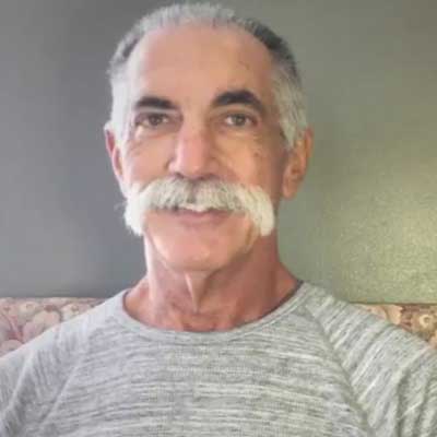 Steve Wapner smiles while wearing a grey t-shirt.