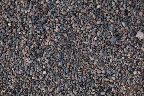 Gravel outdoors comprised of various rocks and pebbles.