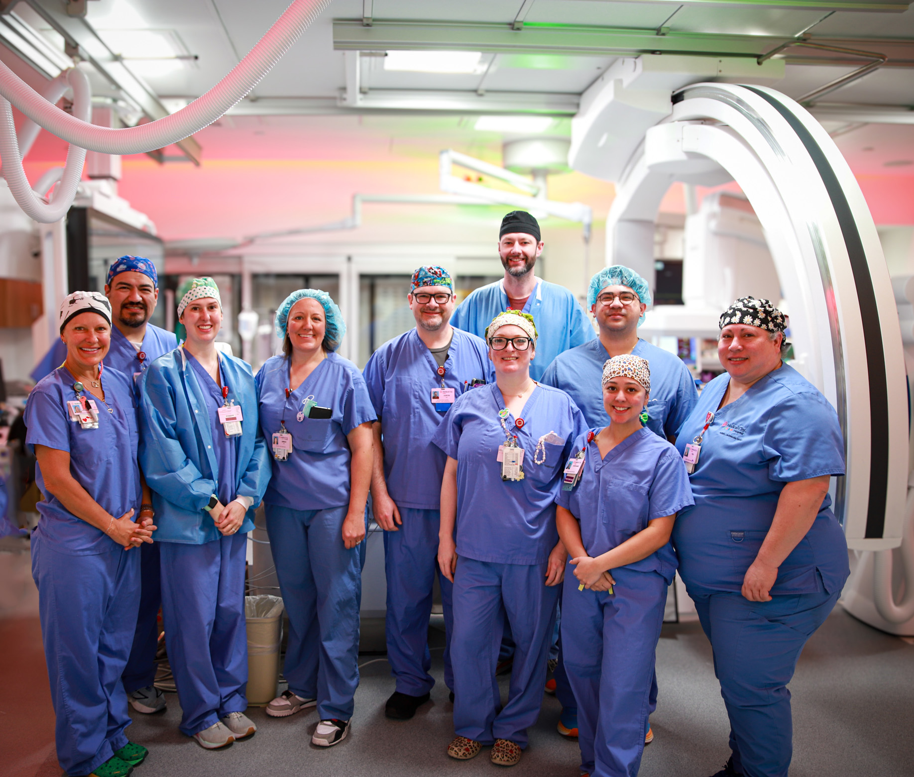 Team standing in front of the new cardiac cath lab equipment.