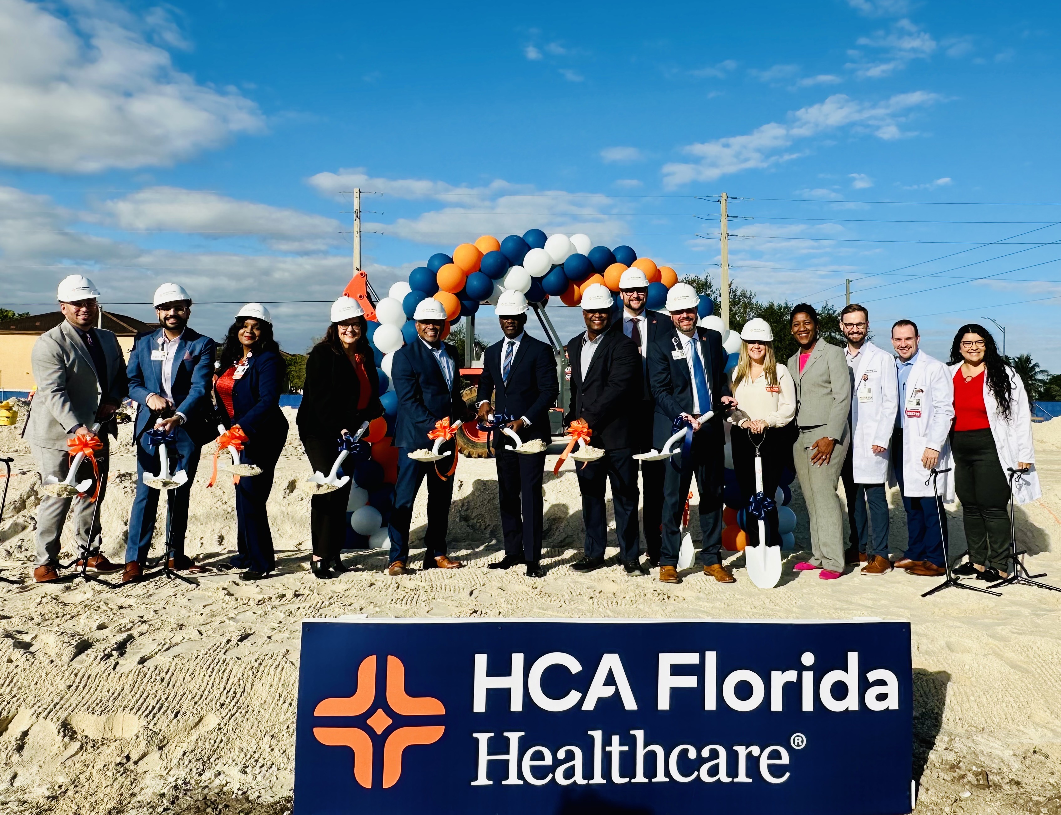 A group stand at a ground breaking ceremony at Kenall Hospital.