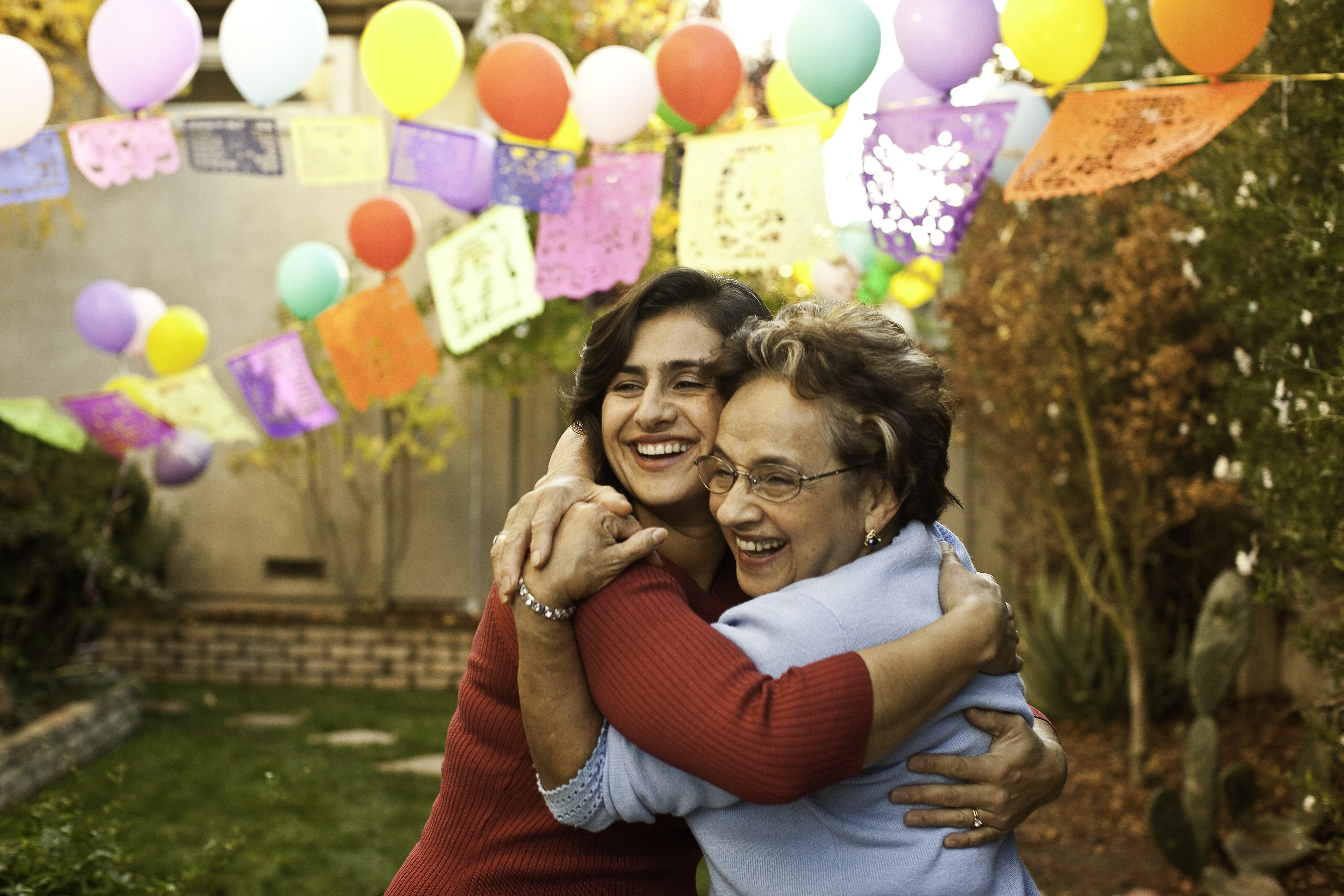 Daughter and elderly mother hugging.