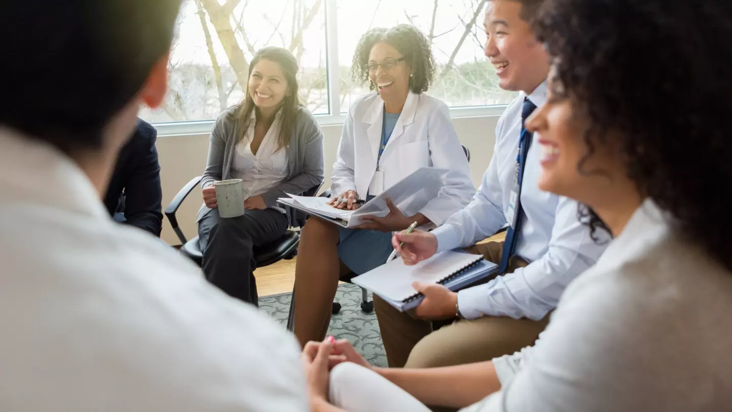 Hospital management staff meets with healthcare professionals.