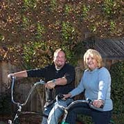 Mike and Dana Stevens pose with their bicycles outdoors.