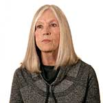 Tawny Sue wears a grey heathered blazer during an interview.
