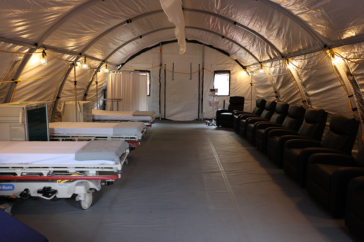 Interior of medical care tent with multiple beds.