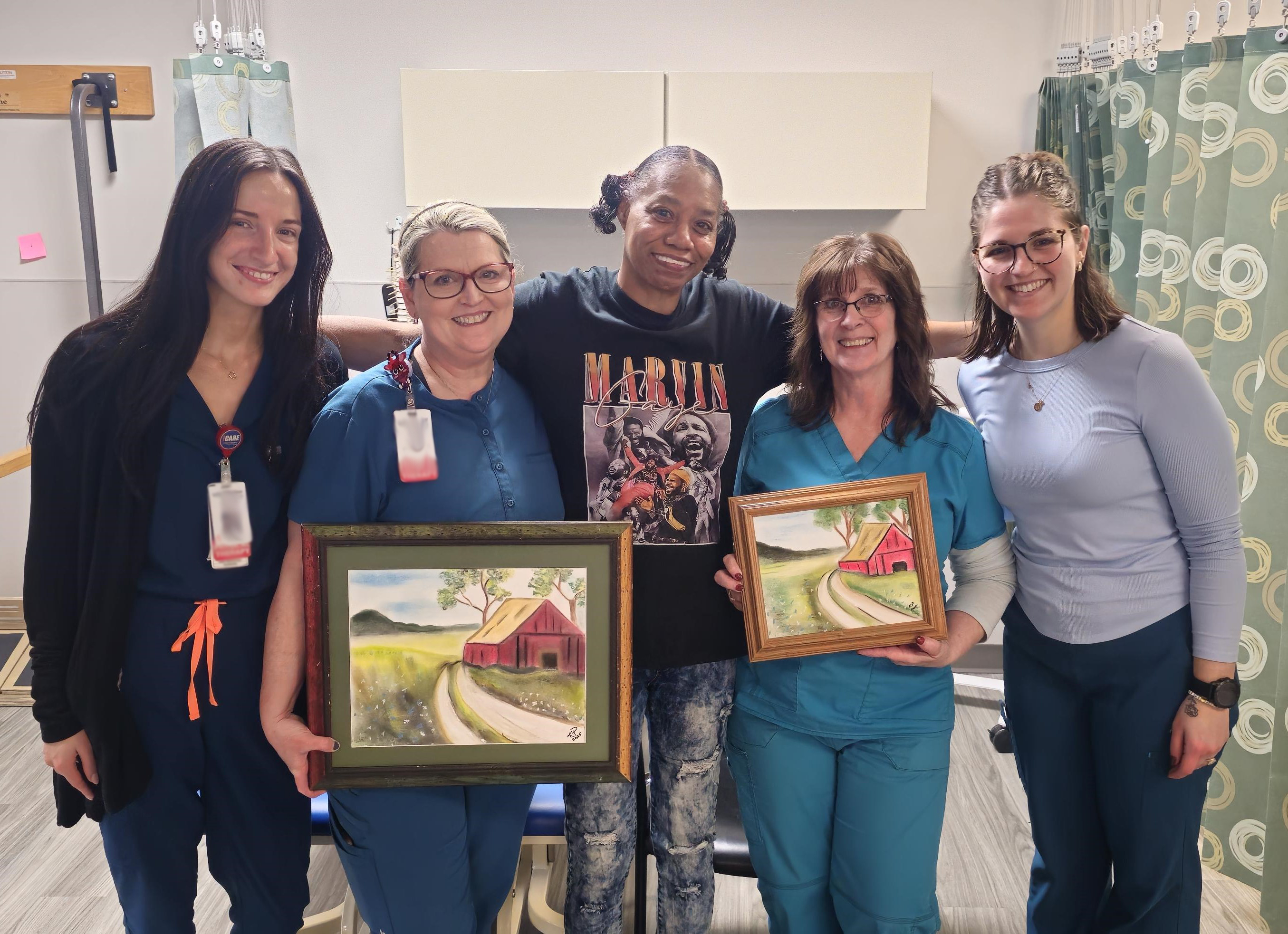 Kim Peacock with members of the outpatient rehabilitation team with one of the pieces of artwork she gave to the team.  