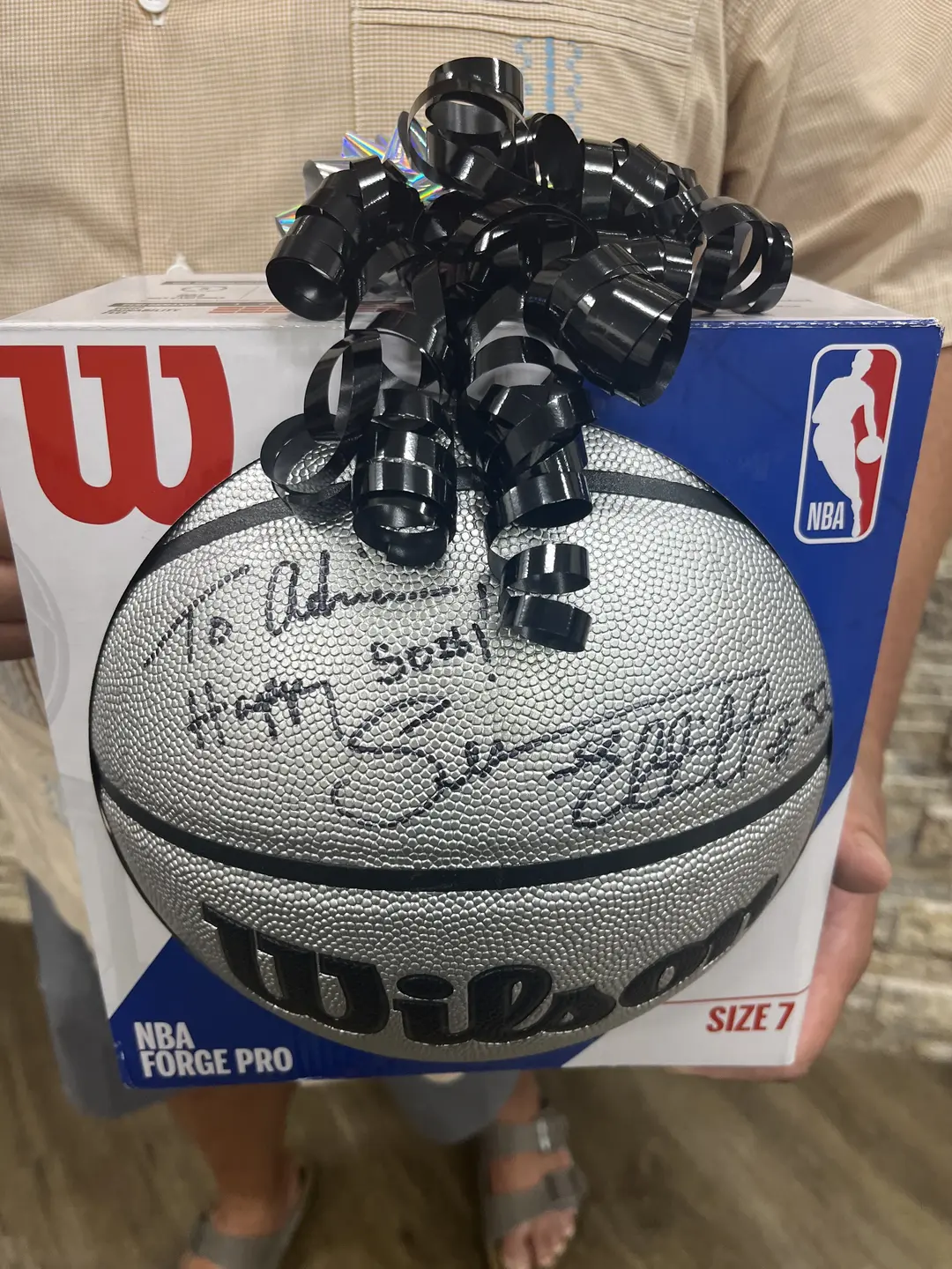 Adrian Lozano's signed basketball with a ribbon on top