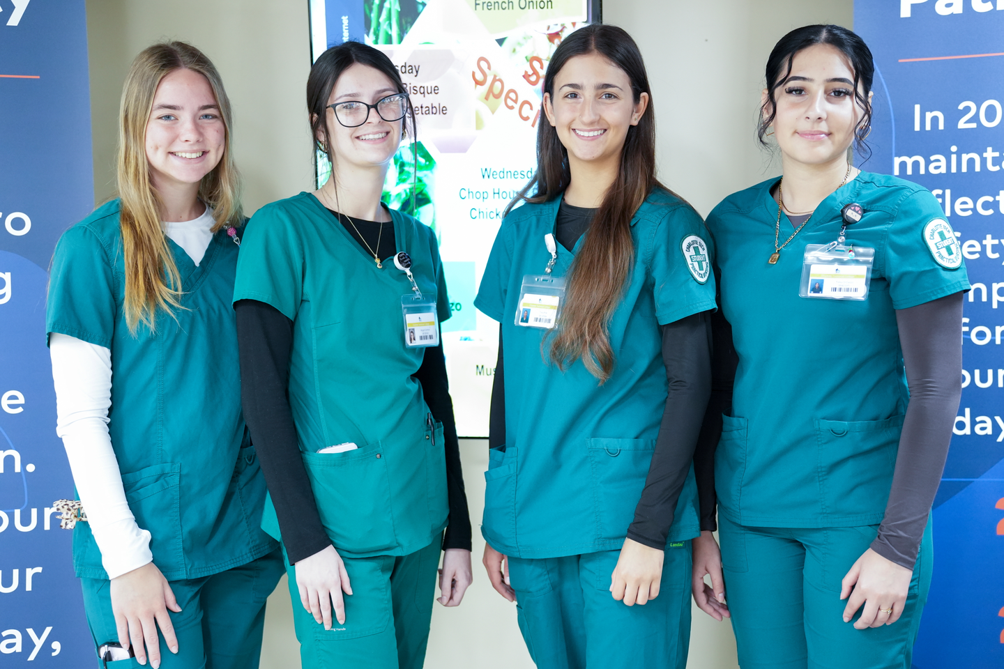Students participating in a healthcare mentorship program through HCA Florida Fawcett Hospital and Big Brothers Big Sisters Sun Coast pose in scrubs during a career development experience.