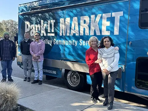Sujatha Venkatraman, and West Valley Community Services staff stand in front of the organization’s Park-It Market mobile food pantry.