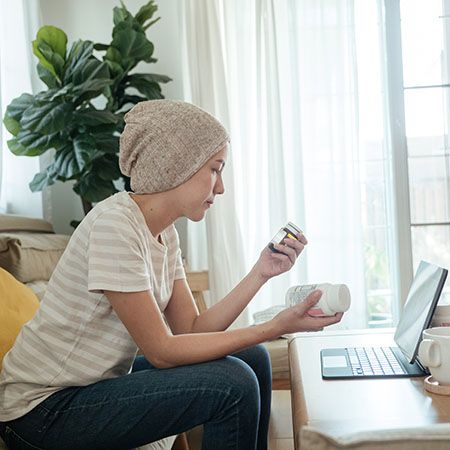 A female cancer patient looks at a prescription bottle