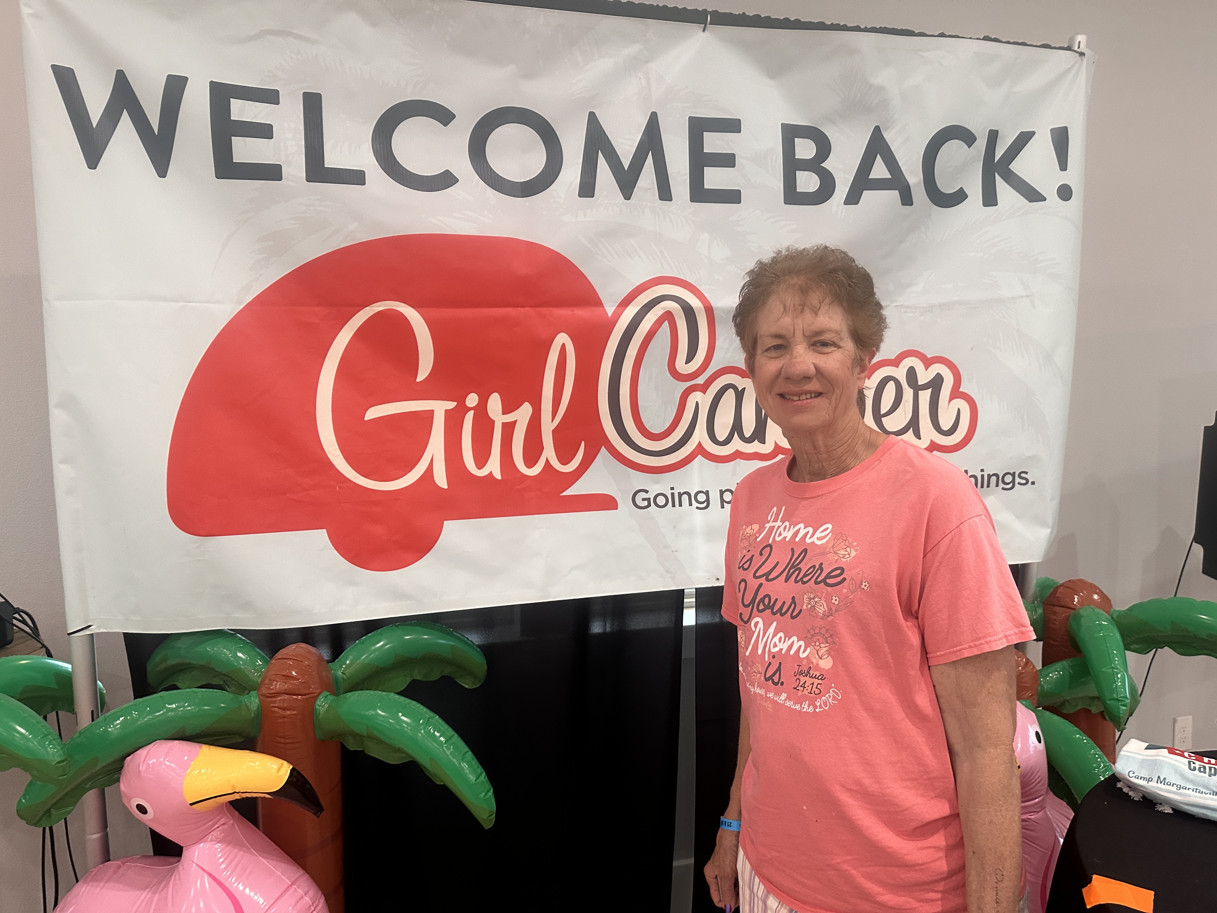 Diane standing in front of GirlCamper signage. 