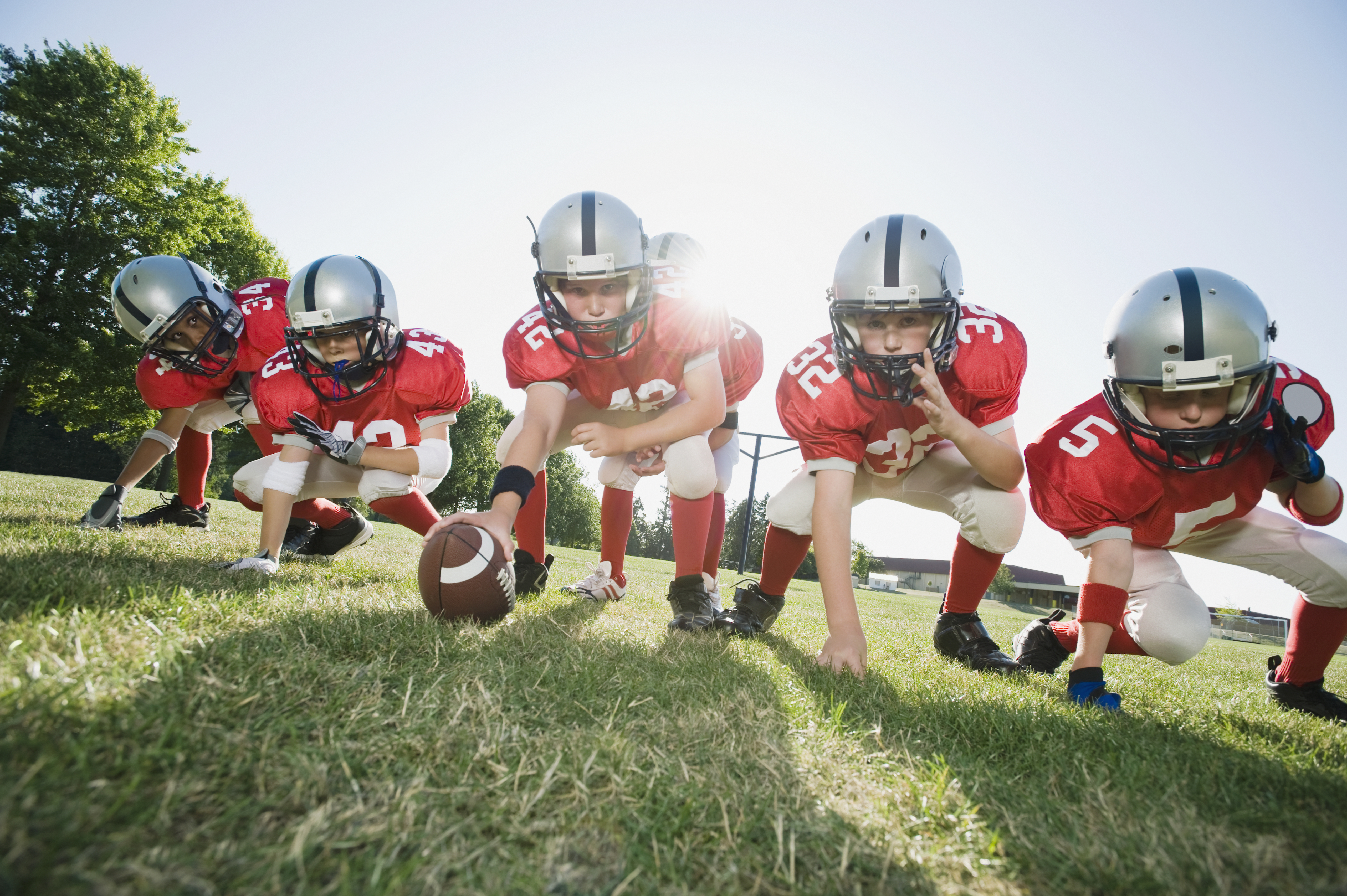 Youth football players at line of scrimmage.