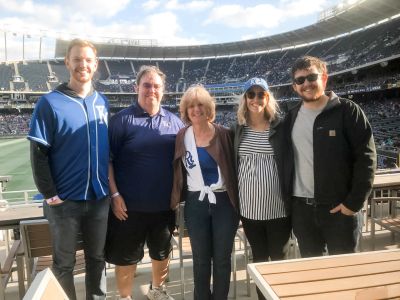Karla O'Malley and her family smile while standing together at a Kansas City baseball game.