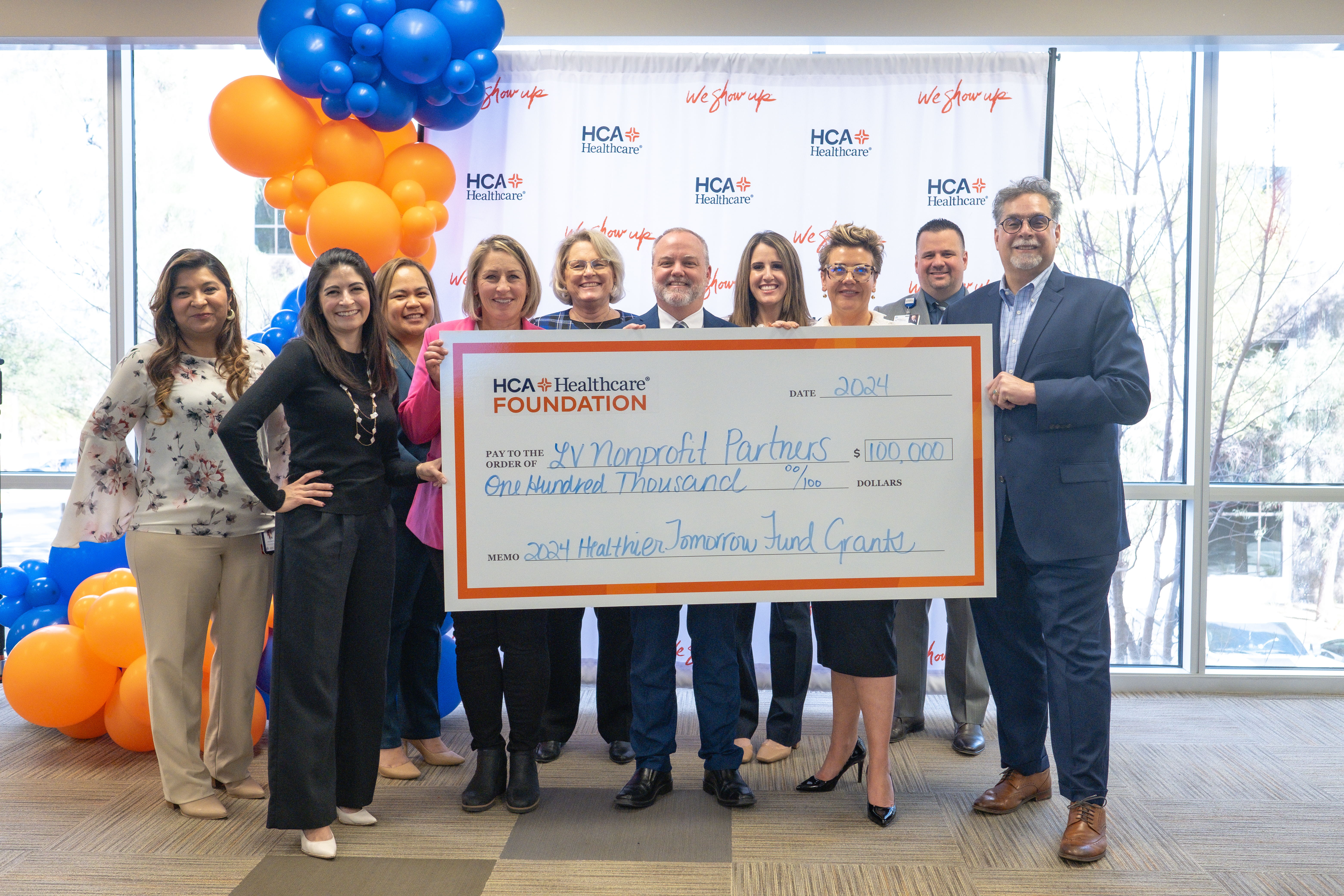 Nonprofit representatives and HCA Far West Division leaders hold an oversized $100,000 check, celebrating grant funding for community health initiatives.