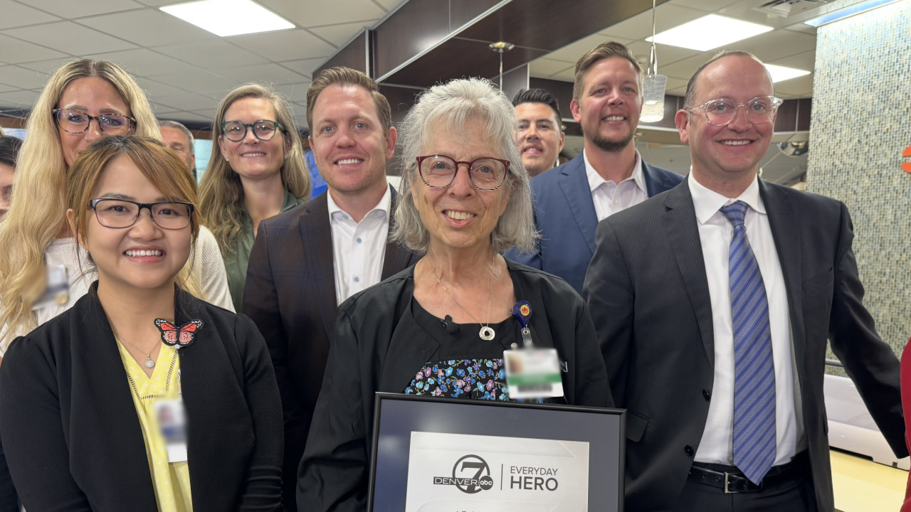 Joann Dawe receives the Denver7 Everyday Hero Award and is surrounded by her HCA HealthONE Rose colleagues.