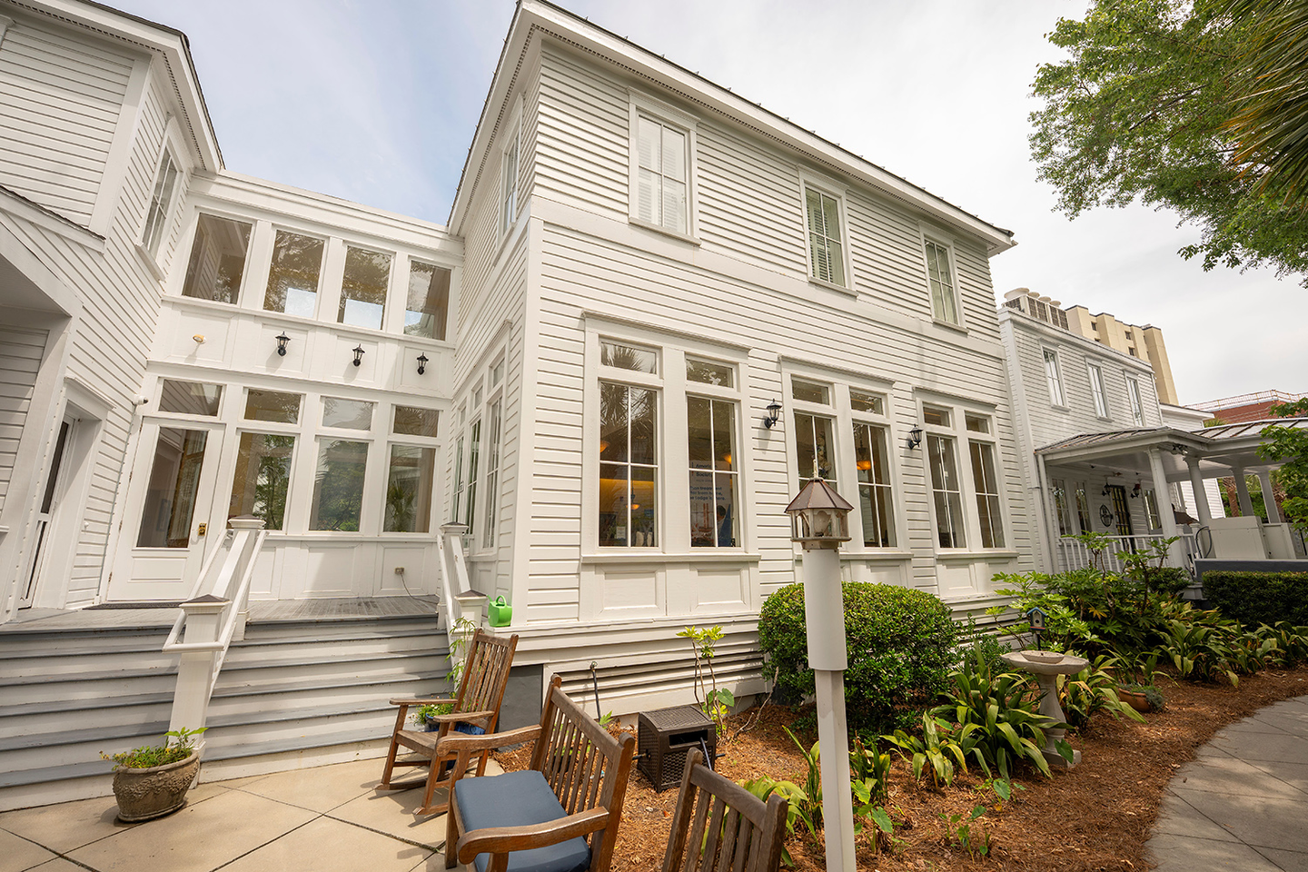 Exterior of Hope Lodge, a white panelled building with rocking chairs out front.