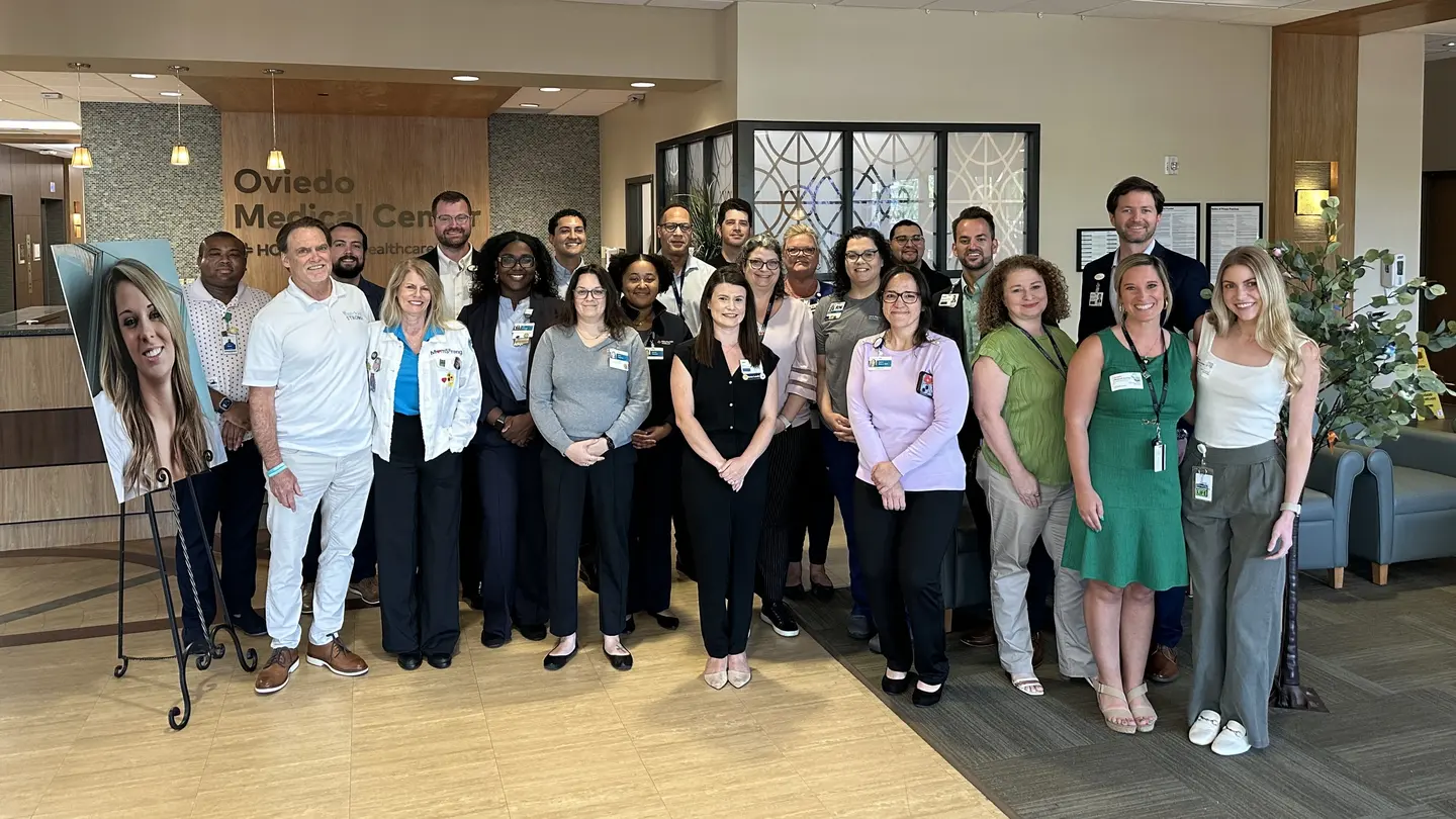 A group photo of the hospital staff and donor's family in the hospital lobby.