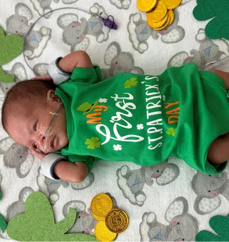 Newborn baby with St. Patricks day outfit.