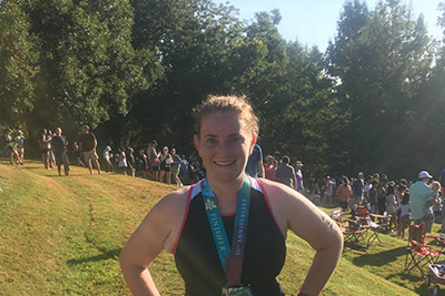 Mackenzie Mitchell wearing workout clothes and a medal.