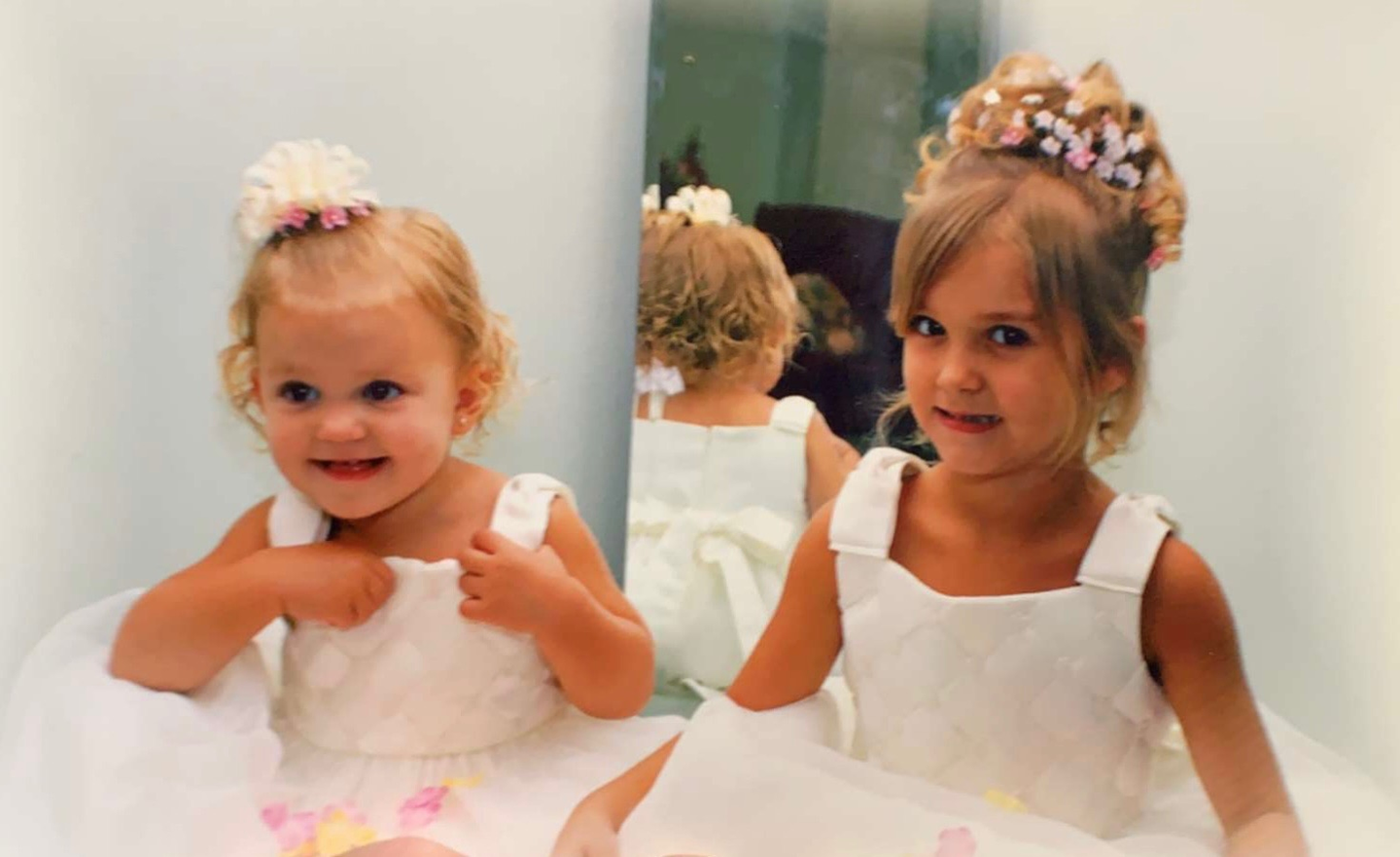 Photo showing of two sister Brynn and Madison Rodgers as young girls with their white princess dresses.
