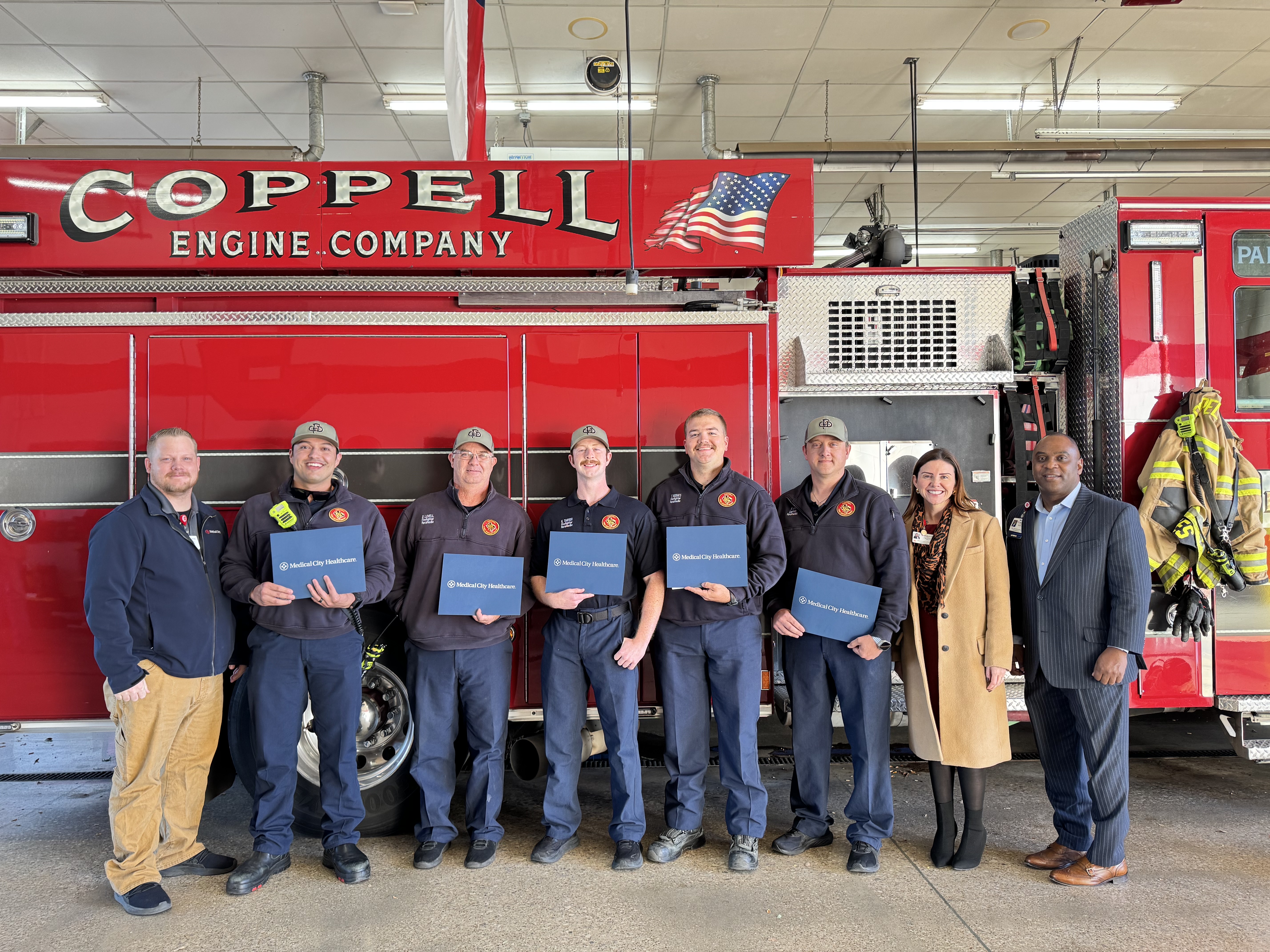 Coppel firefighers standing in front of fire truck holding their awards.