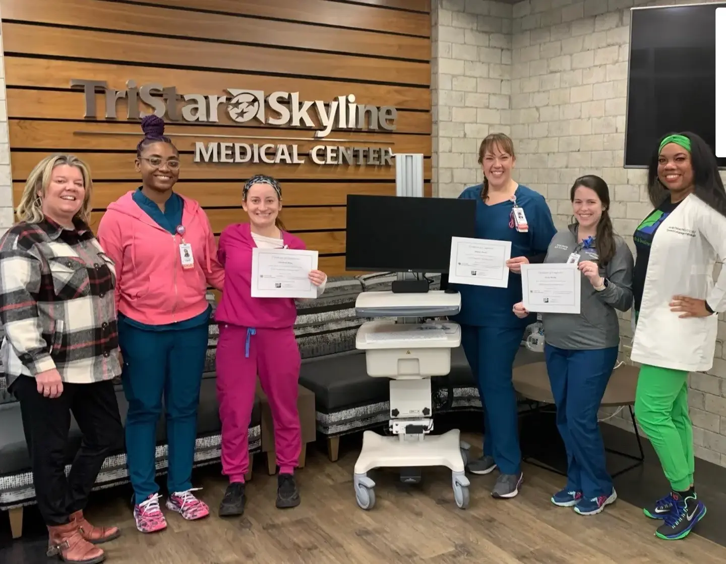Speech language pathology team showing off their certificates.