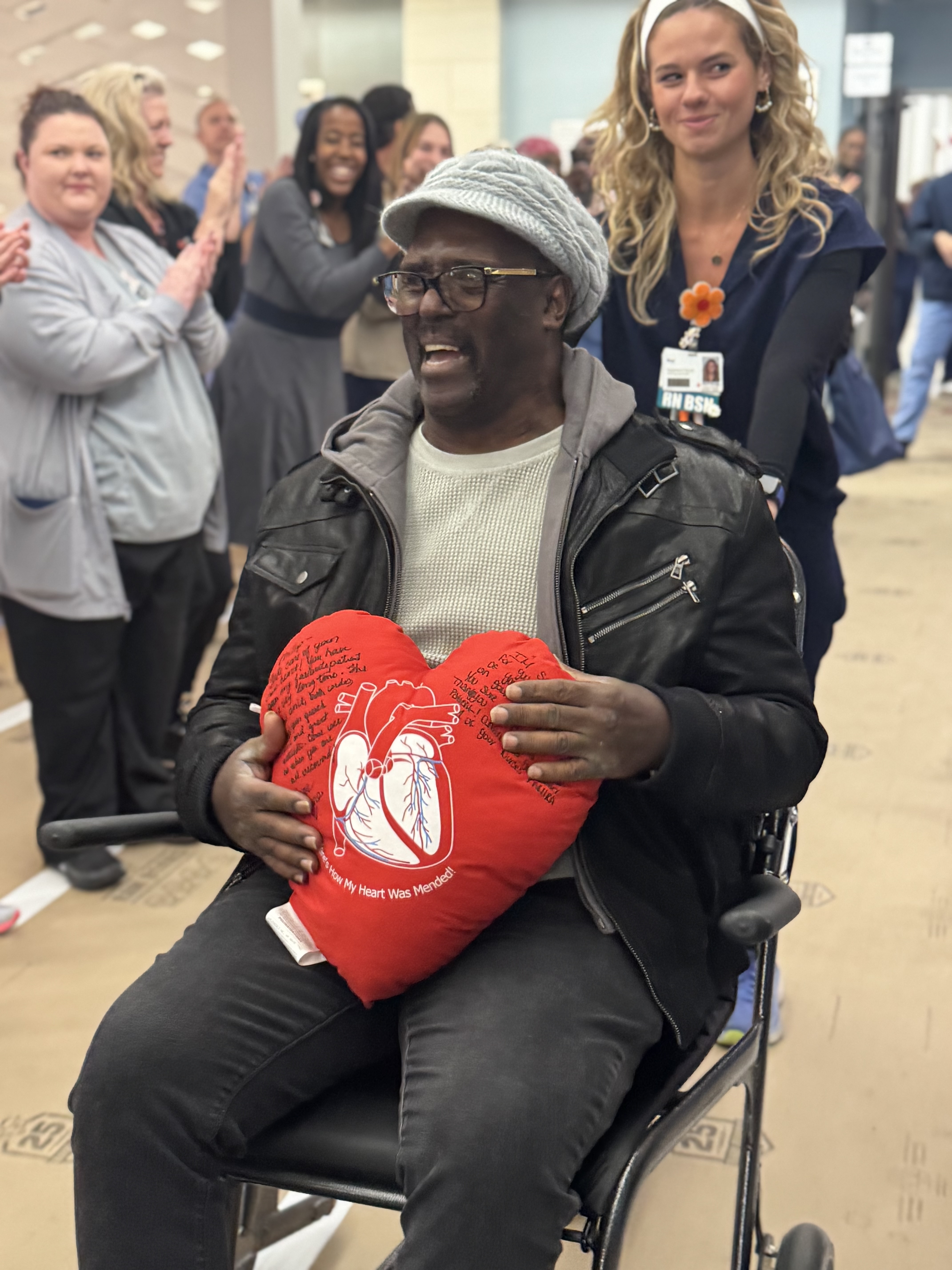 Phillip Allen leaving the hospital holding signed plush red heart.