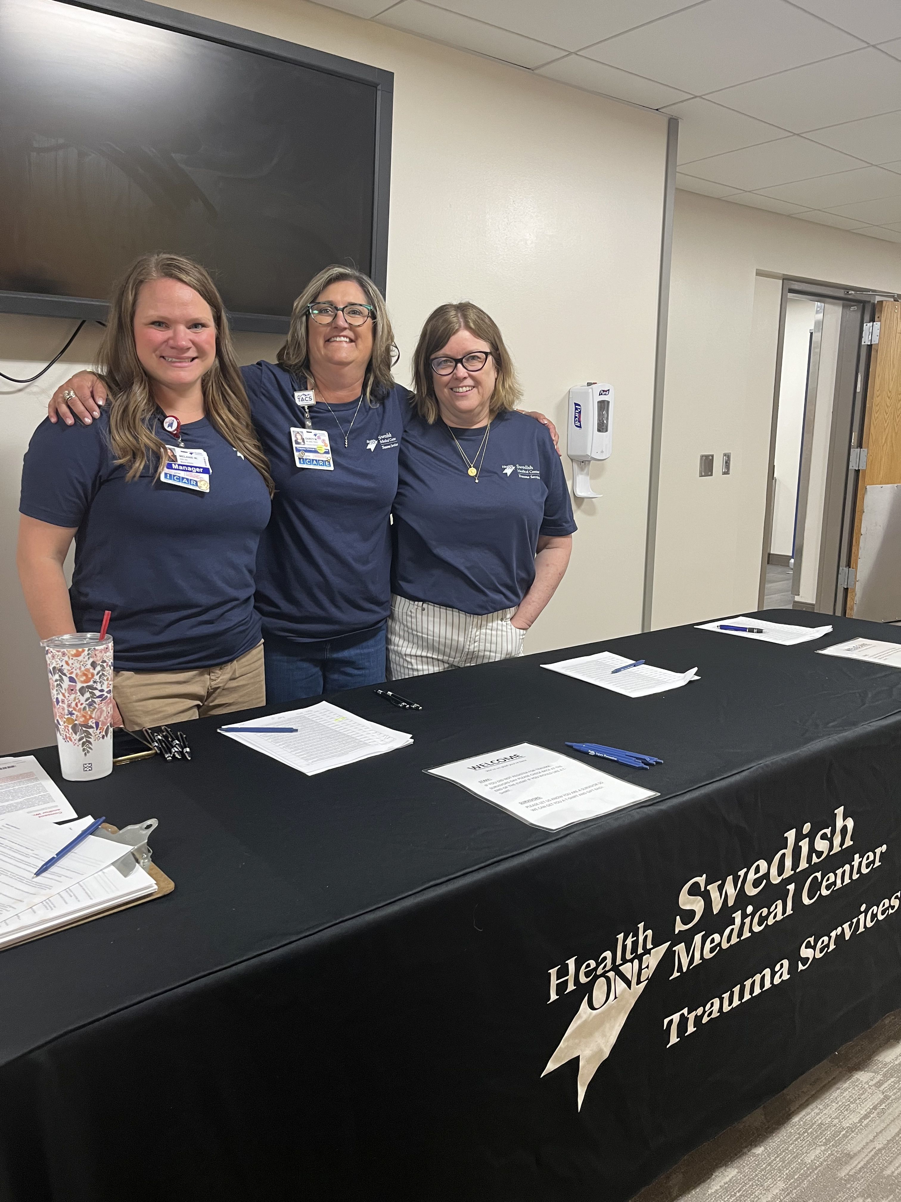 Three Swedish Medical Center colleagues stand behind table