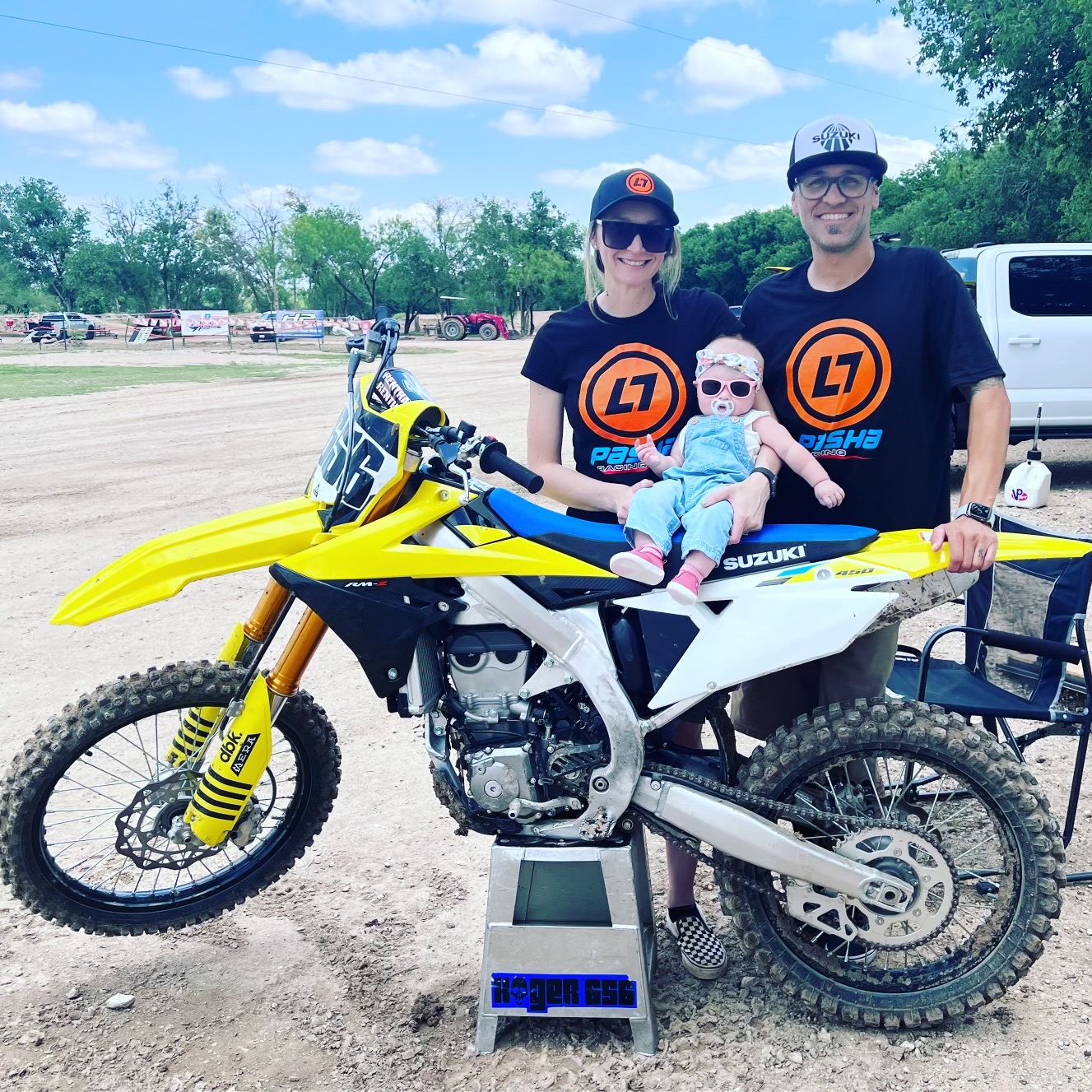Kody and his wife, Kristi pose with their child by their dirt bike