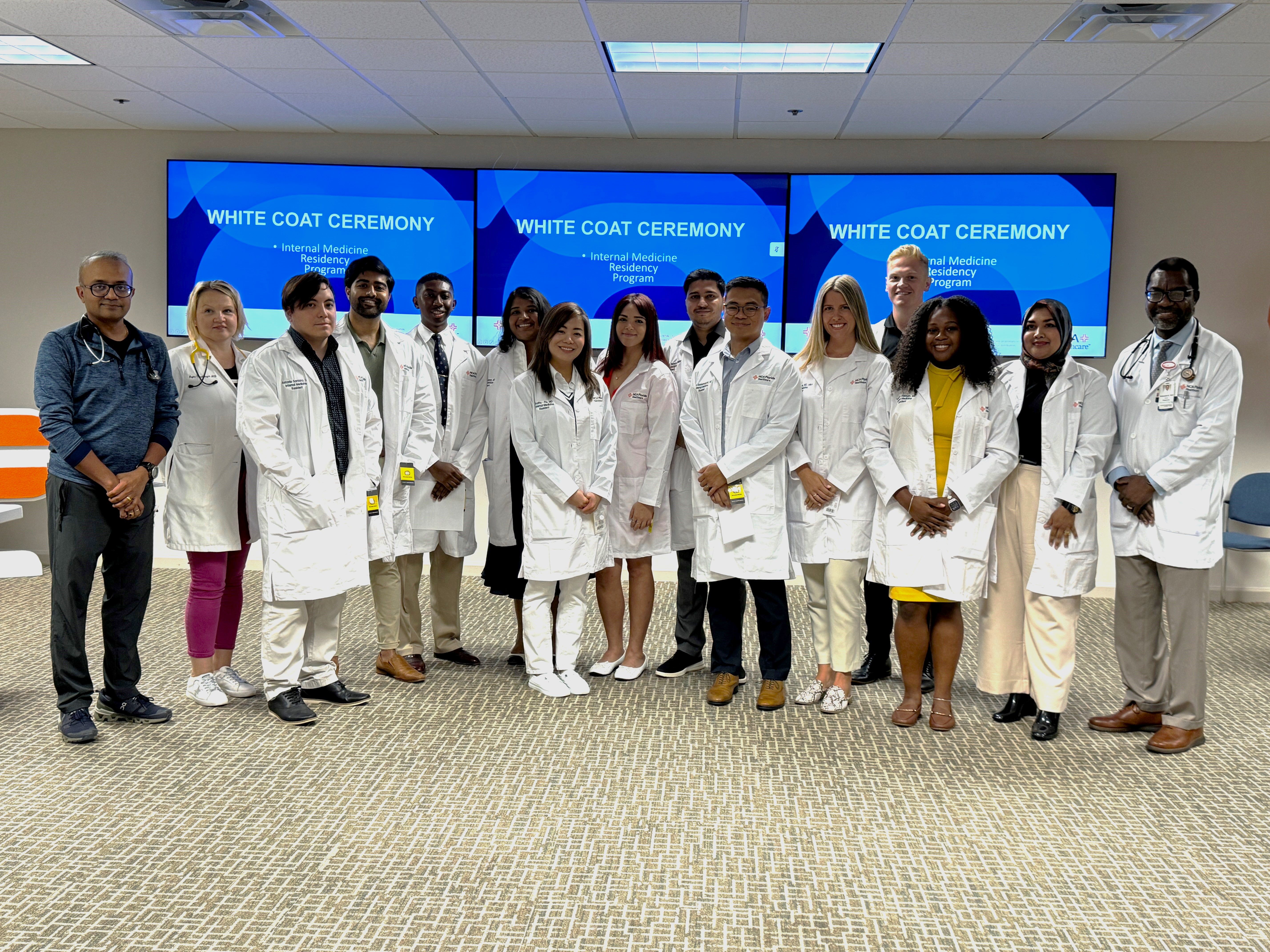Group of doctors in white coats stand smiling