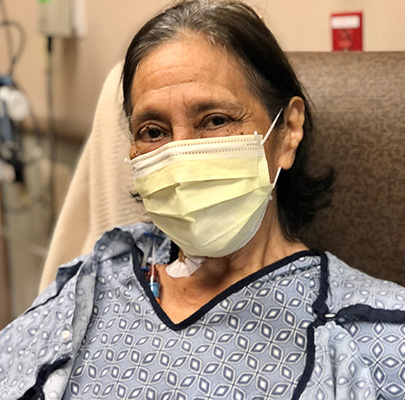 Cancer survivor Maria Garcia wearing a yellow face mask.