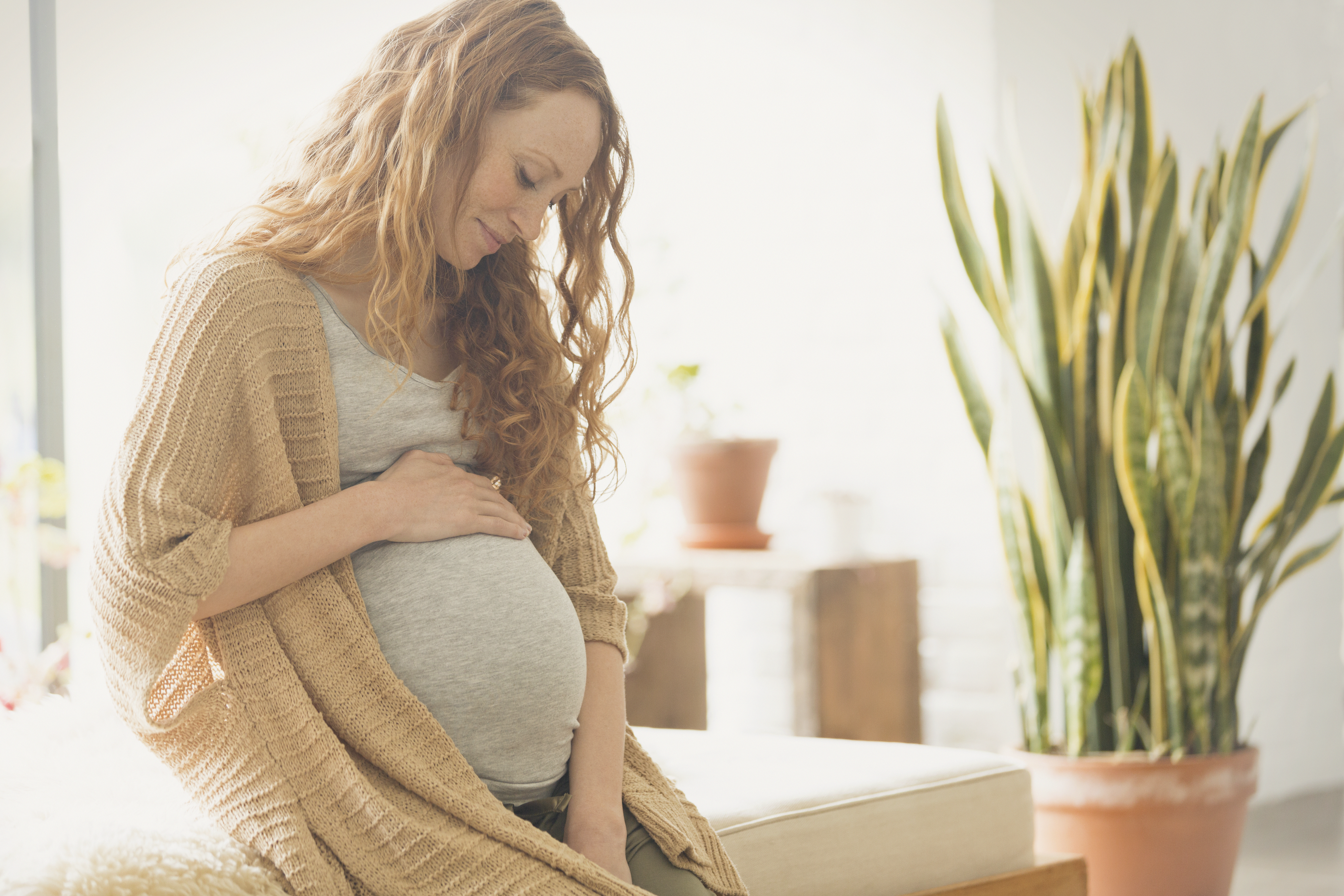 Pregnant woman with her hand on her stomach.