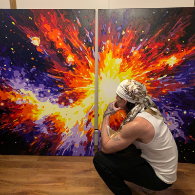 A person crouches in front of two colorful paintings shaped like a thyroid gland.